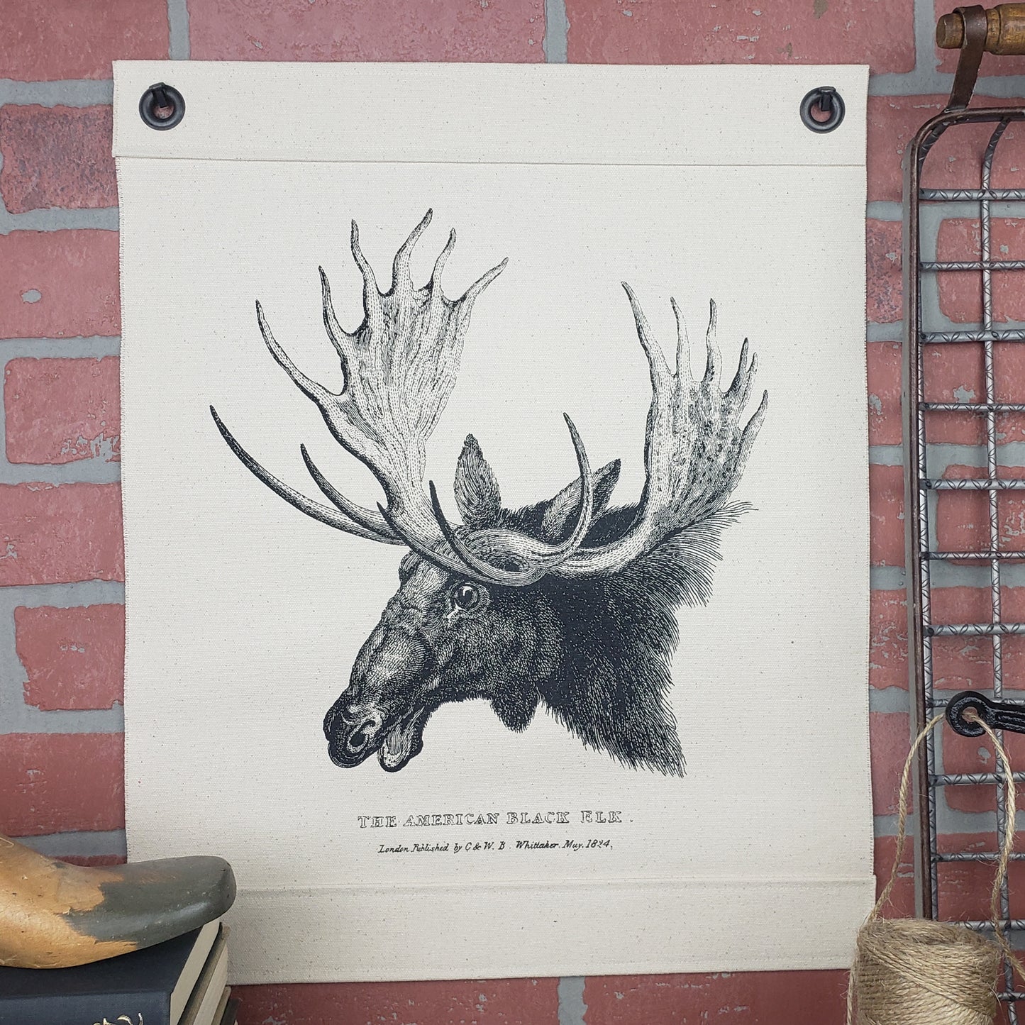 Vintage image of a Moose {American Black Elk} c.1824 screen printed on our Inked Canvas wall hanging, wall decor, or wall art. Hand made in the USA by Heart in Hand Mercantile using natural, unbleached 100% Cotton Heavy Duck Canvas and hung by two grommets. Two antique reproduction square nails included.